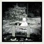 Black and white child on bridge looking at camera